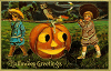 Two young boys at Halloween carrying an enormous jack-o'-lantern on a pole.