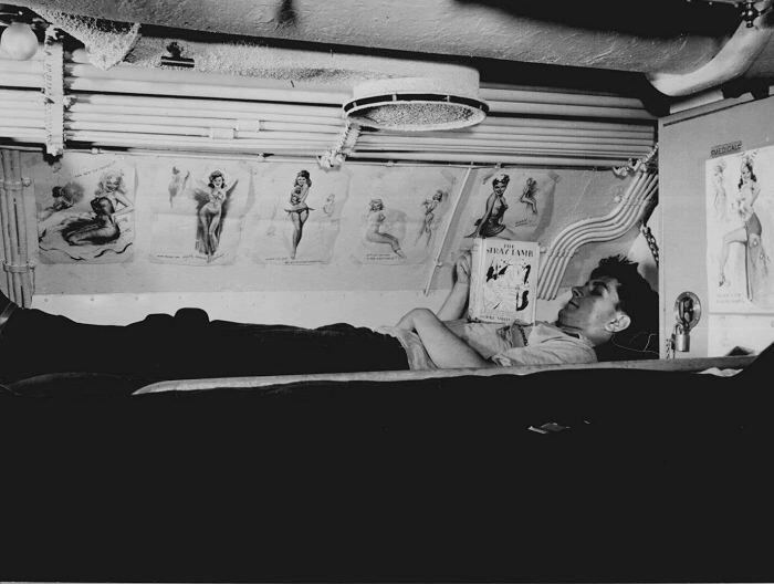 Sailor reading in his bunk aboard USS CAPELIN at submarine base New London, Conn.
