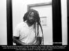Mumia Abu-Jamal through plexiglass in prison.